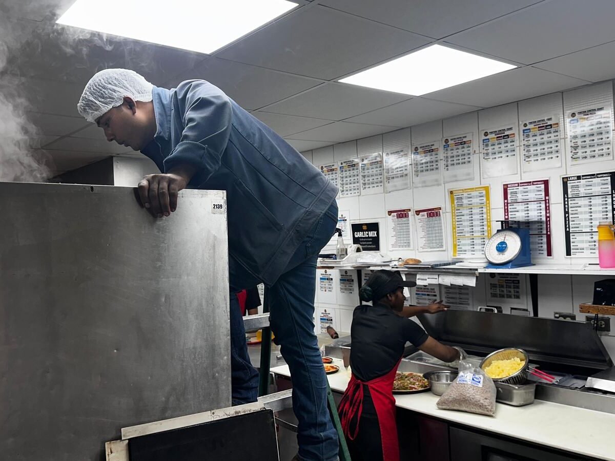 Working on equipment in a busy commercial kitchen