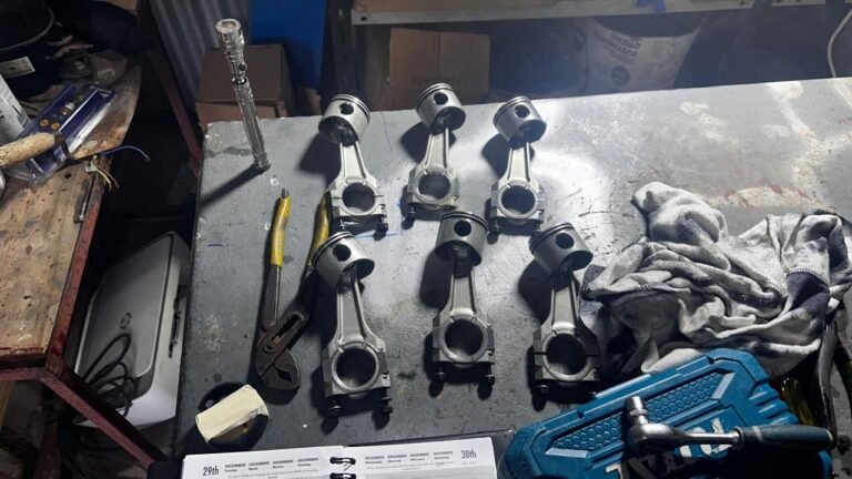 Pistons and connecting rods laid out for inspection